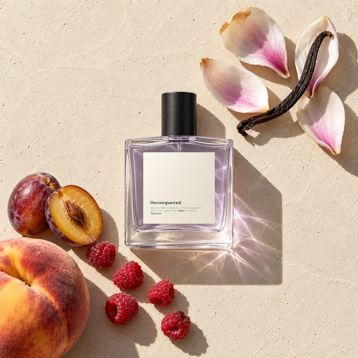 Unconquered perfume bottle on sunlit plaster with peach, plums, raspberries, magnolia petals and vanilla